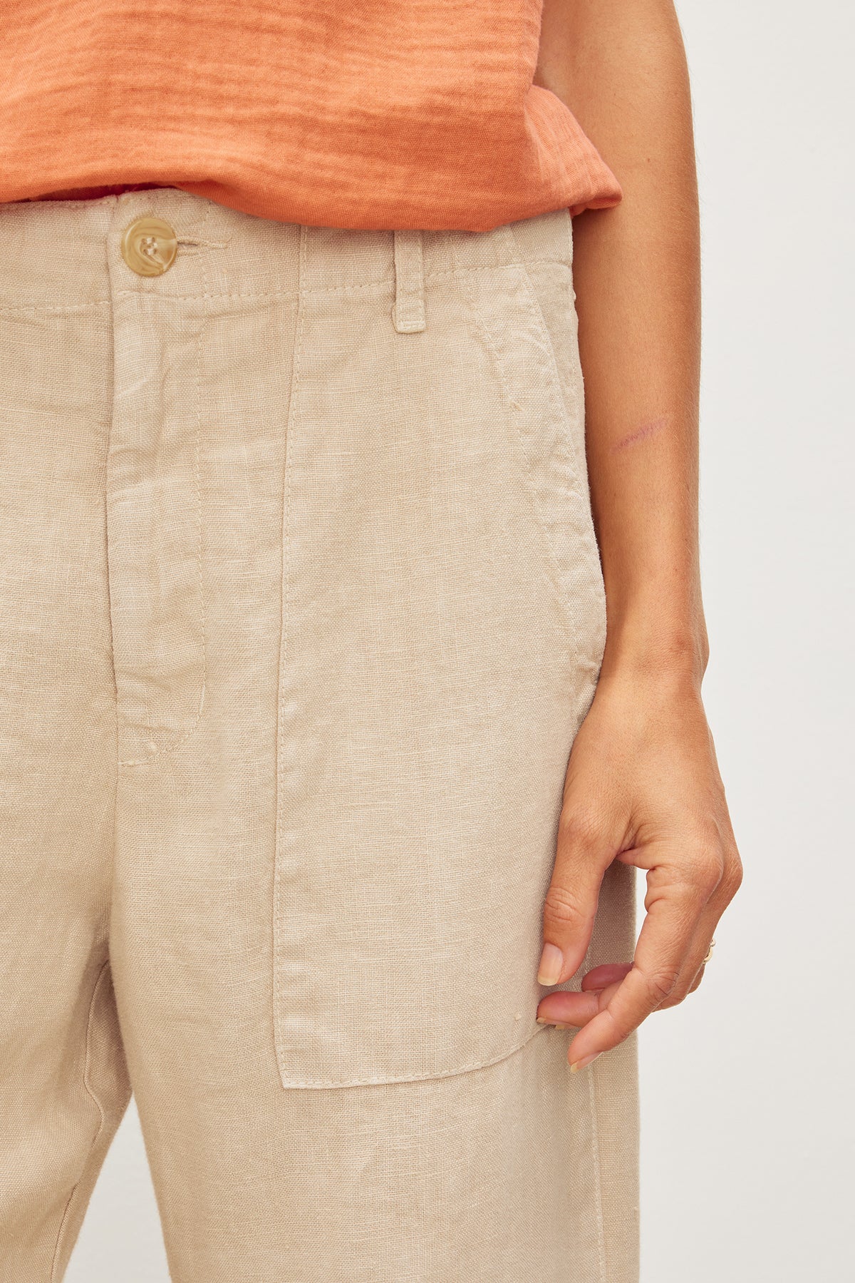   Close-up of a person wearing Velvet by Graham & Spencer's DRU HEAVY LINEN PANT with patch pocket detailing. 