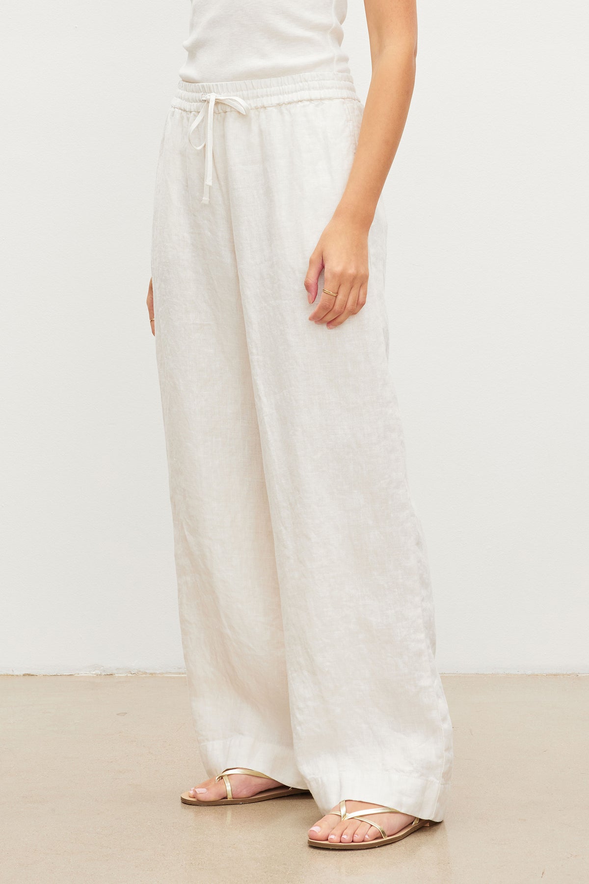   A woman wearing Gwyneth heavy linen pants by Velvet by Graham & Spencer with a relaxed drape and a white t-shirt. 