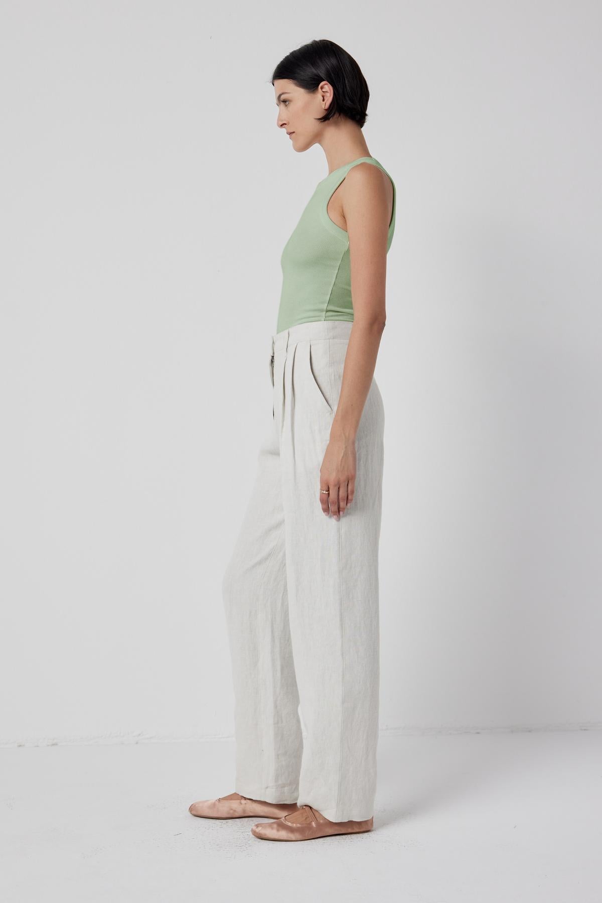 The model is wearing a Cruz Tank Top by Velvet by Jenny Graham and white linen pants that stretch comfortably over the body.-36198187958465