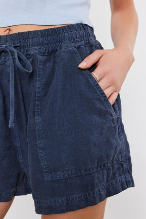 Close-up of a person wearing a Velvet by Graham & Spencer Sutton Heavy Linen Short, with a focus on the textured fabric and details like the waistband and pockets.