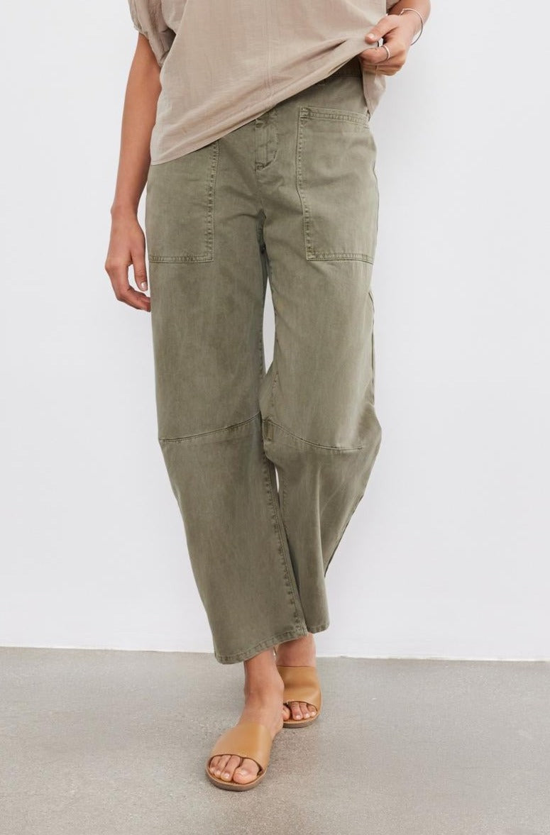 A person wearing Velvet by Graham & Spencer's BRYLIE SANDED TWILL UTILITY PANT with patch pockets and tan slide sandals, standing against a plain white background.-37000518041793