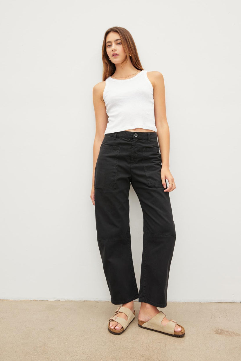 A woman wearing Velvet by Graham & Spencer's BRYLIE SANDED TWILL UTILITY PANT and a white tank top.