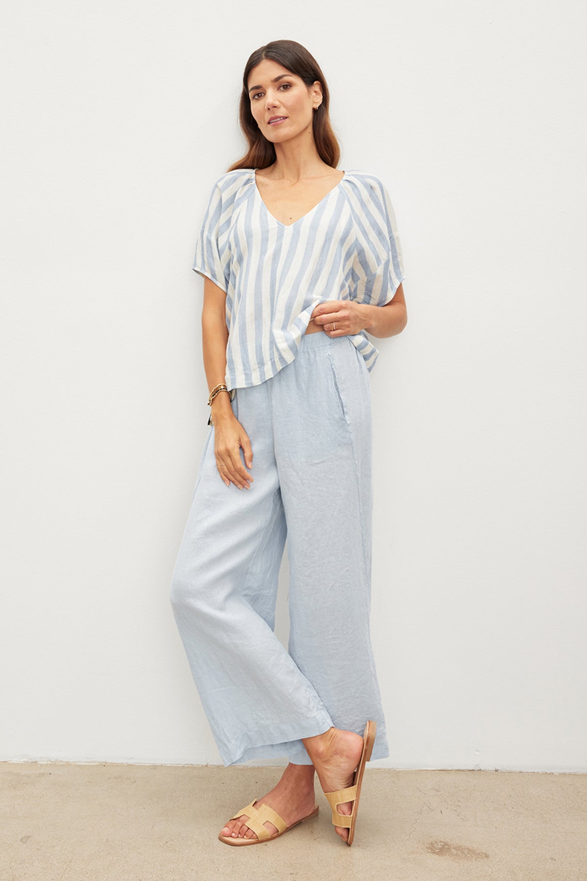 The model is wearing a lightweight linen woven striped top and Velvet by Graham & Spencer wide leg pants.-36002577481921
