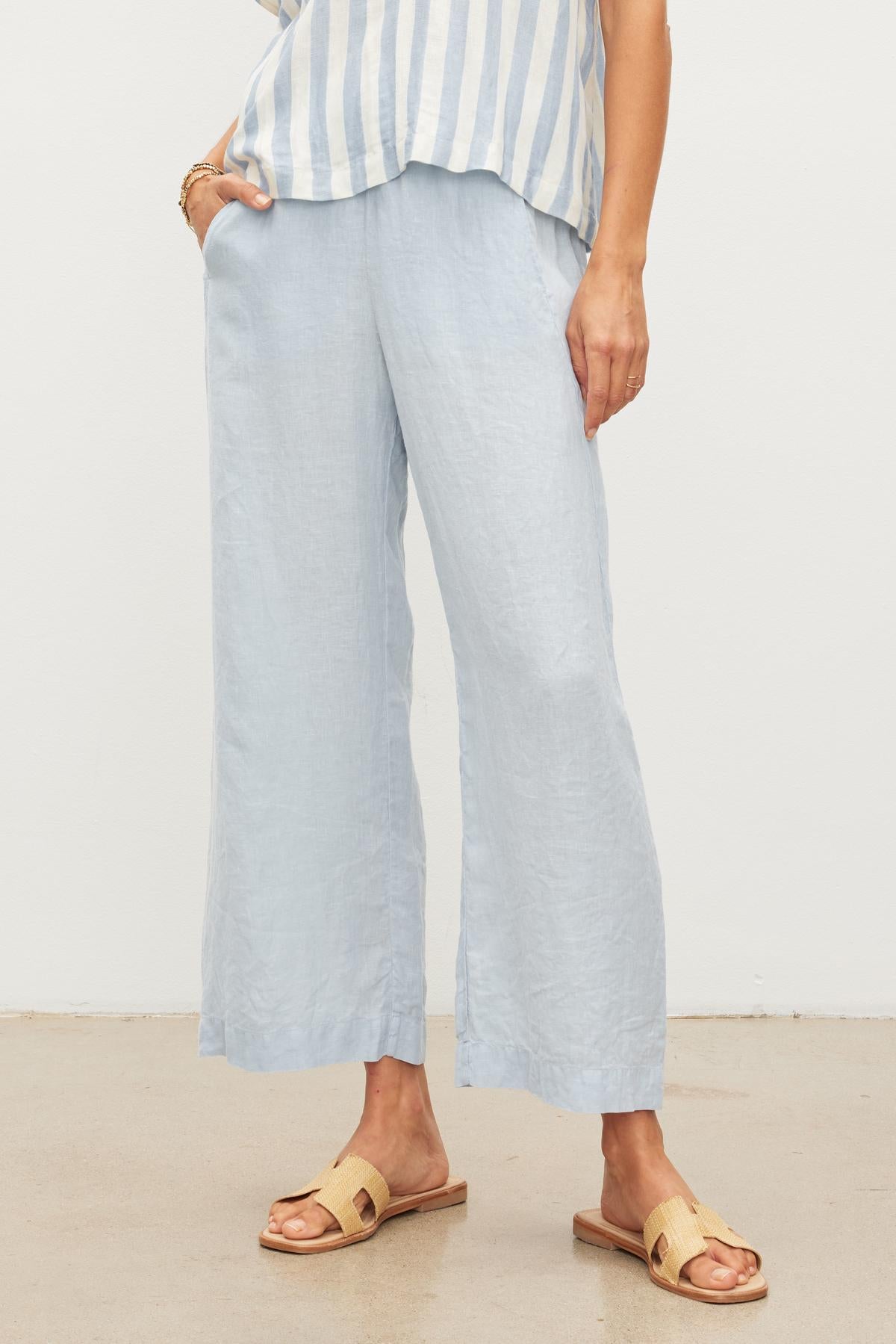 A woman wearing Velvet by Graham & Spencer's LOLA LINEN PANT with an elastic waist and lightweight linen woven fabric.-36002577514689