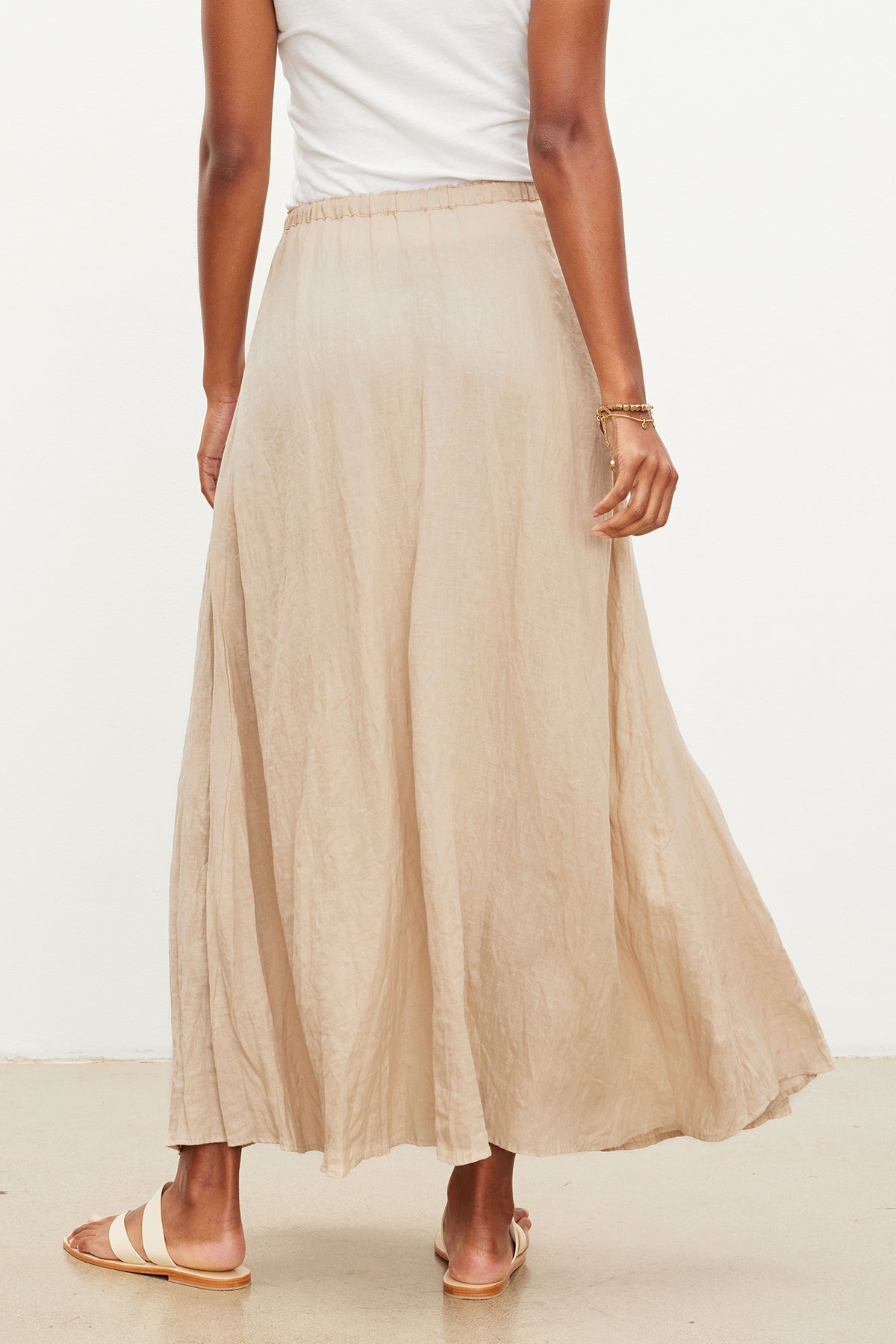 The back view of a woman wearing a Velvet by Graham & Spencer BAILEY LINEN MAXI SKIRT.-35955424166081