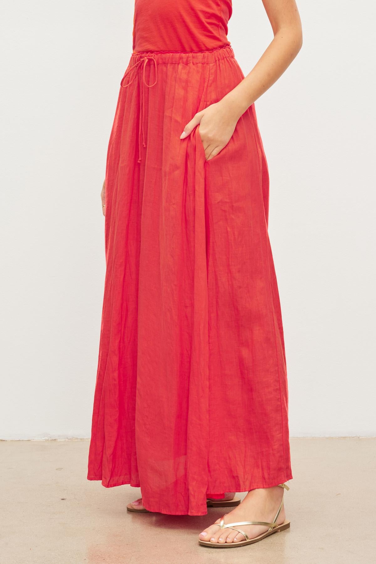 A woman wearing a Velvet by Graham & Spencer Bailey Linen Maxi Skirt with an elastic drawstring waist.-35955626803393
