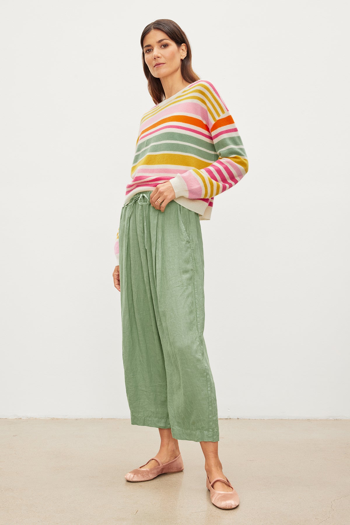   The model is wearing a Velvet by Graham & Spencer ANNY CASHMERE STRIPED CREW NECK SWEATER with ribbed details and green culottes. 