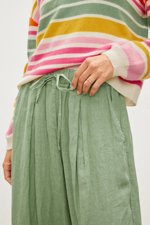 A woman wearing a green Velvet by Graham & Spencer Hannah Linen Wide Leg Pant.