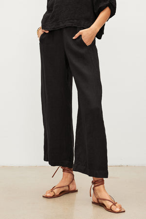 A woman wearing Velvet by Graham & Spencer's LOLA LINEN PANT with an elastic waist.