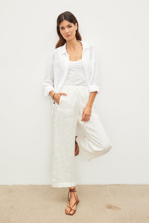A woman wearing LOLA LINEN PANT by Velvet by Graham & Spencer lightweight linen pants with an elastic waist and a white shirt.