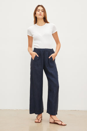A woman in blue LOLA LINEN PANTS by Velvet by Graham & Spencer with an elastic waist.