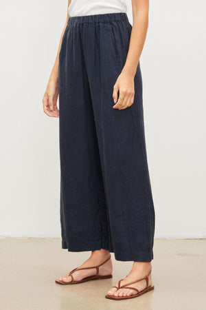 A woman wearing a pair of Velvet by Graham & Spencer LOLA LINEN PANT with an elastic waist.