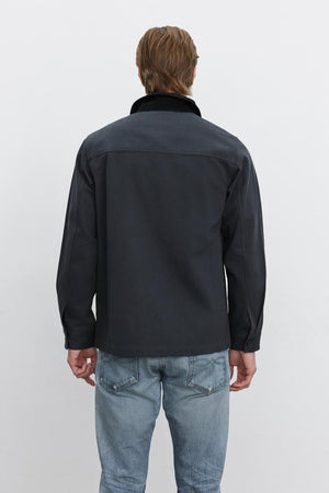 A person with brown hair, seen from the back, wearing the EMORY JACKET by Velvet by Graham & Spencer in dark blue structured cotton canvas and light blue jeans against a plain white background.