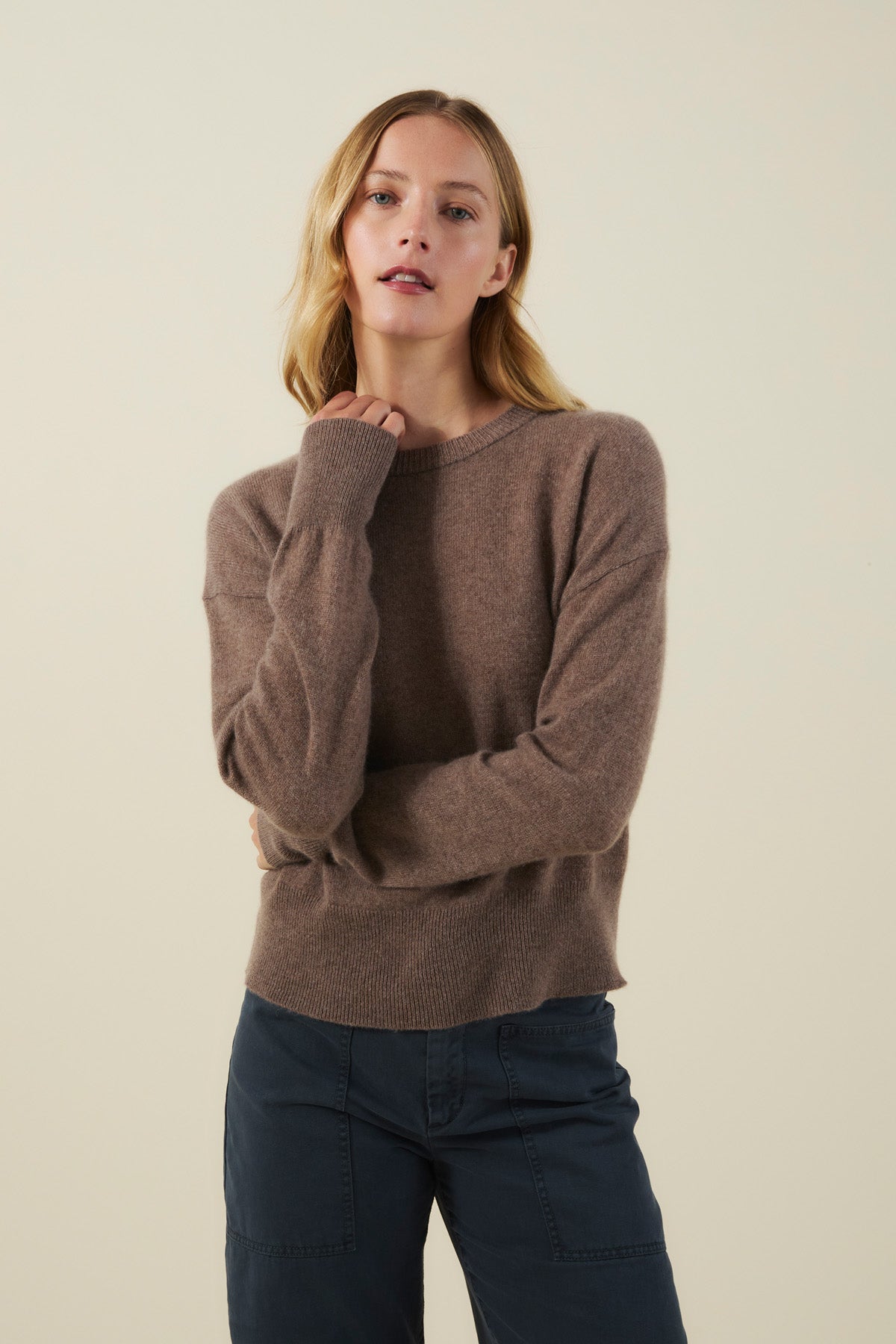A woman wearing a brown, soft knit ALBA CASHMERE SWEATER by Velvet by Graham & Spencer with dark pants.-46498787197121