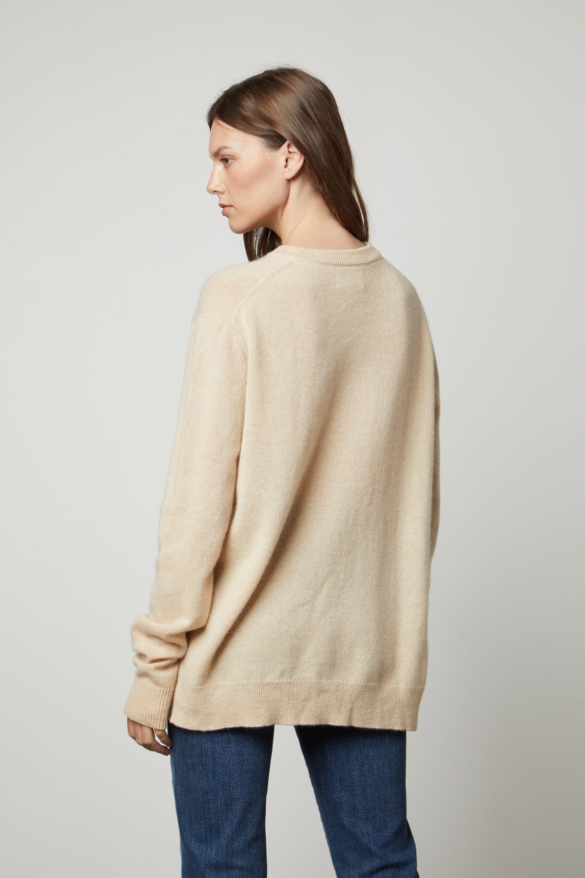 The view of a woman wearing an oversized Velvet by Graham & Spencer Harmony Cashmere V-Neck Sweater.-35655722795201
