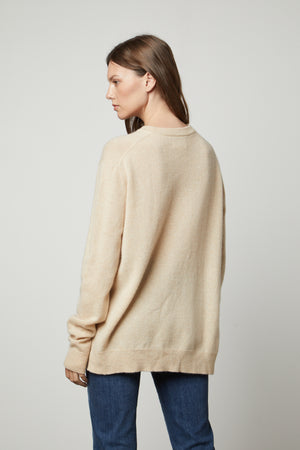 The view of a woman wearing an oversized Velvet by Graham & Spencer Harmony Cashmere V-Neck Sweater.