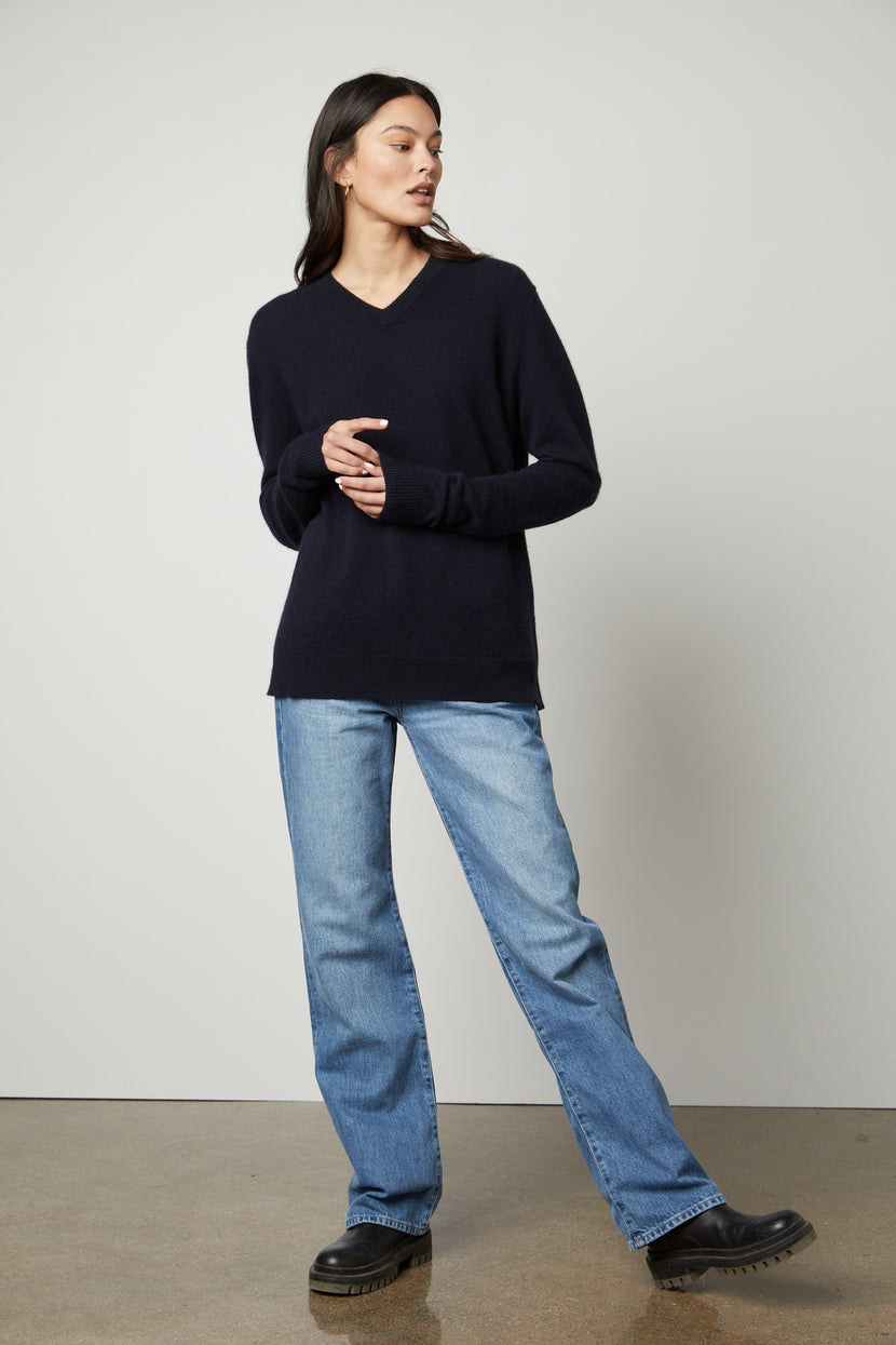 The model is wearing jeans and a Velvet by Graham & Spencer Harmony Cashmere V-Neck Sweater.