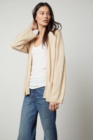 The model is wearing jeans and a Velvet by Graham & Spencer LILA CASHMERE CARDIGAN.