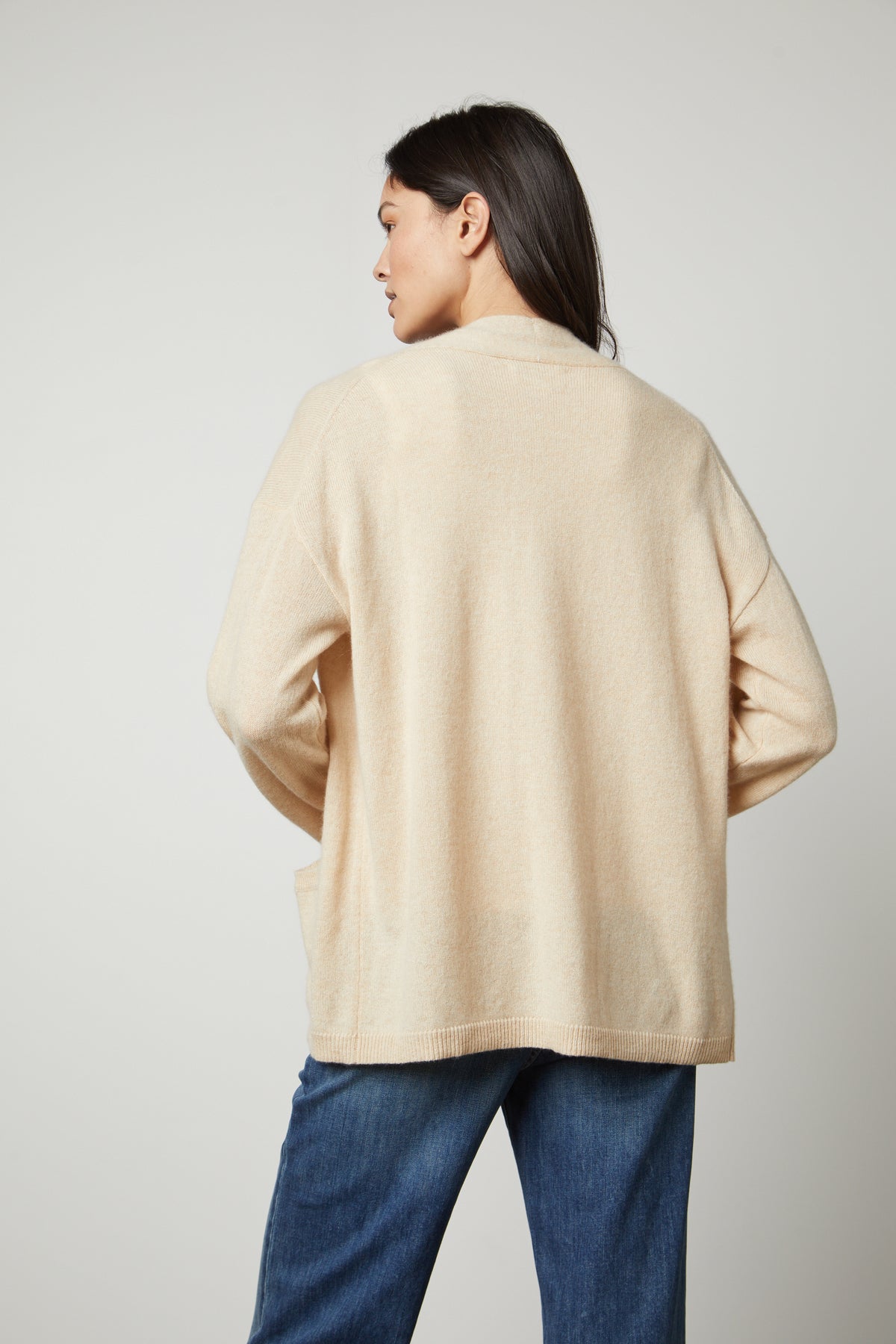 The back view of a woman wearing a Velvet by Graham & Spencer LILA CASHMERE CARDIGAN and jeans.-26910345887937