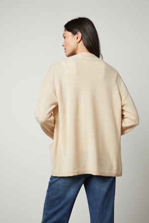 The back view of a woman wearing a Velvet by Graham & Spencer LILA CASHMERE CARDIGAN and jeans.