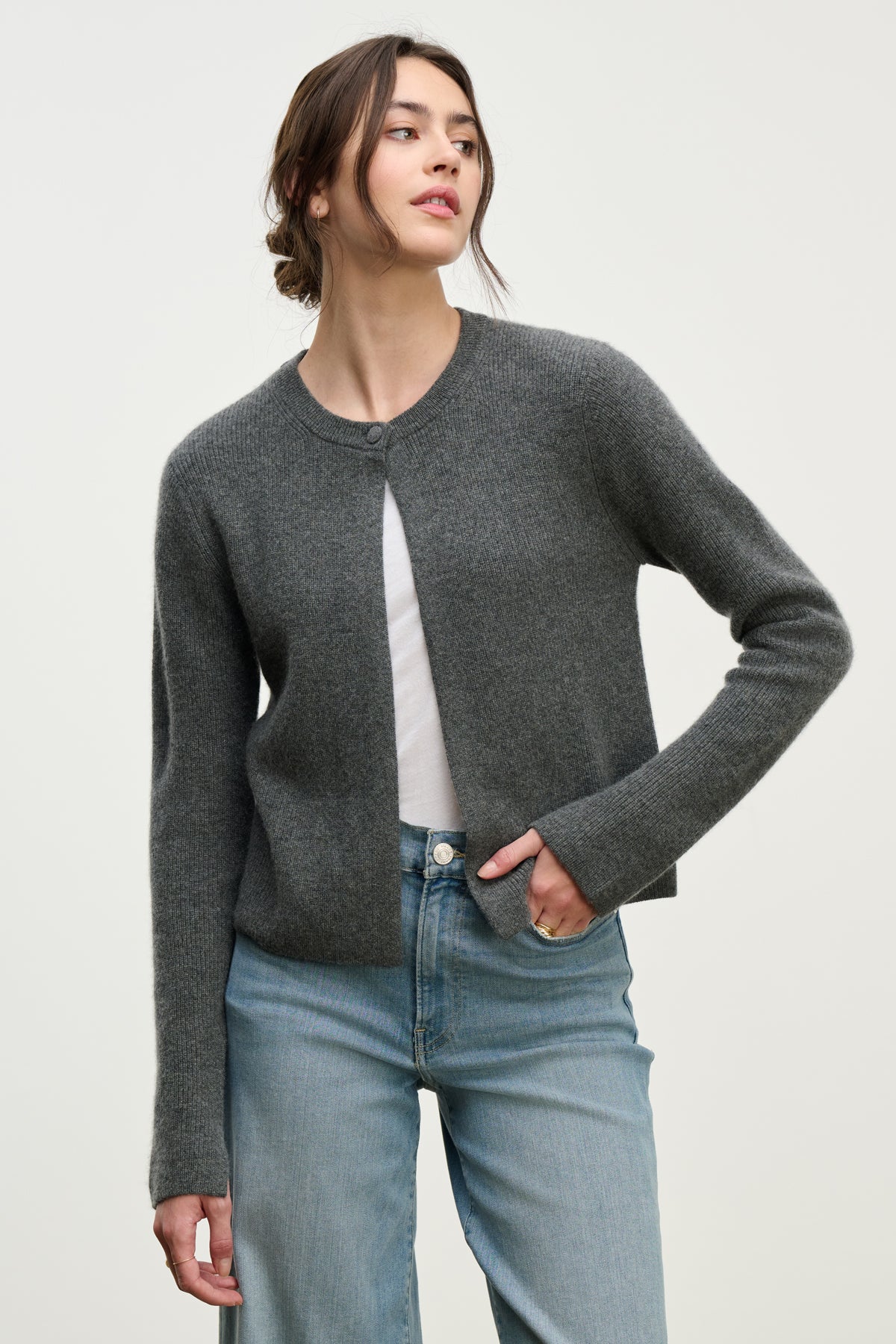 A woman models the TINA CASHMERE CARDIGAN by Velvet by Graham & Spencer, layering it stylishly over a white shirt and light blue jeans against a simple light background.-39814940590273