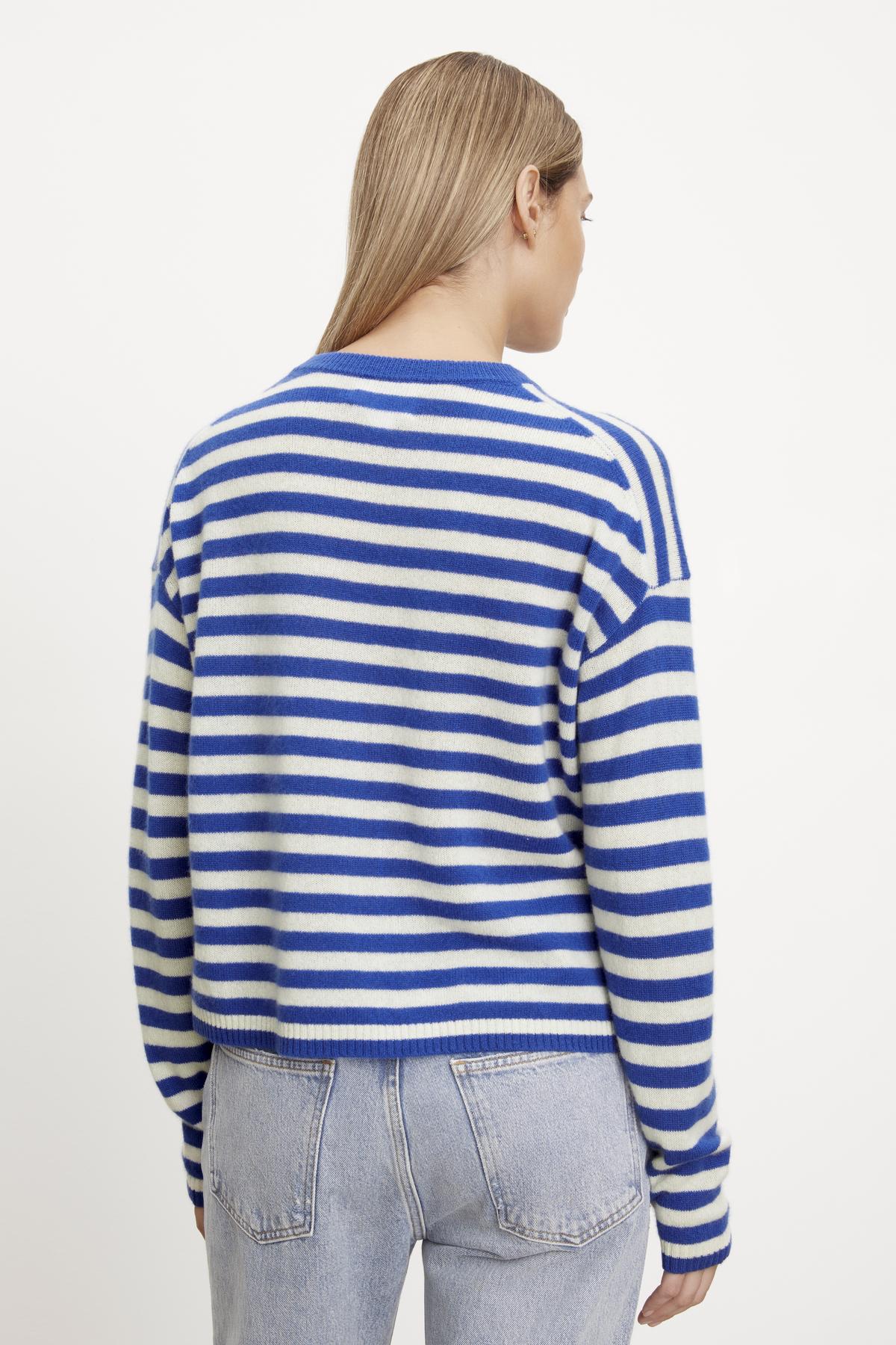  The back view of a woman wearing a Velvet by Graham & Spencer ALYSSA CASHMERE STRIPED CREW NECK SWEATER. 