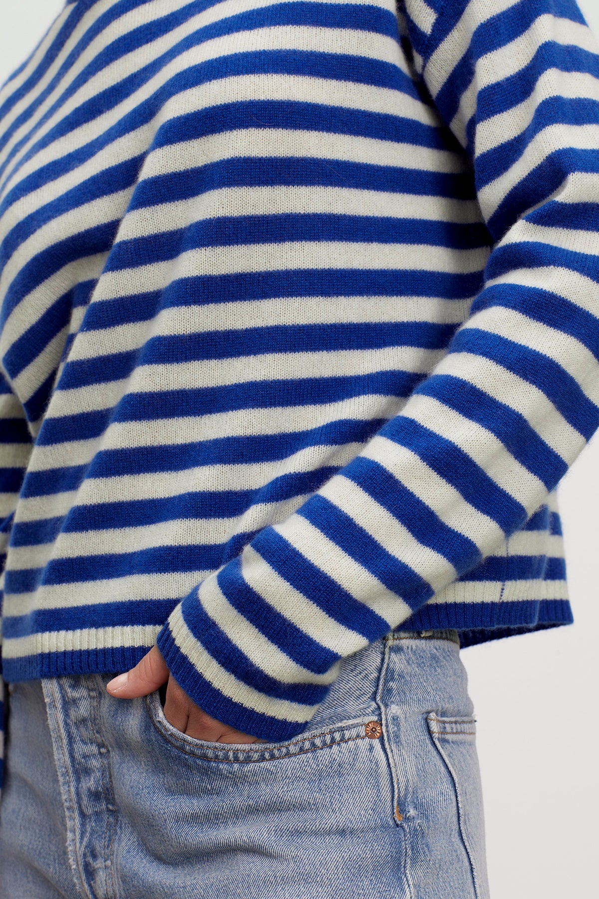   A woman wearing the Velvet by Graham & Spencer ALYSSA CASHMERE STRIPED CREW NECK SWEATER. 