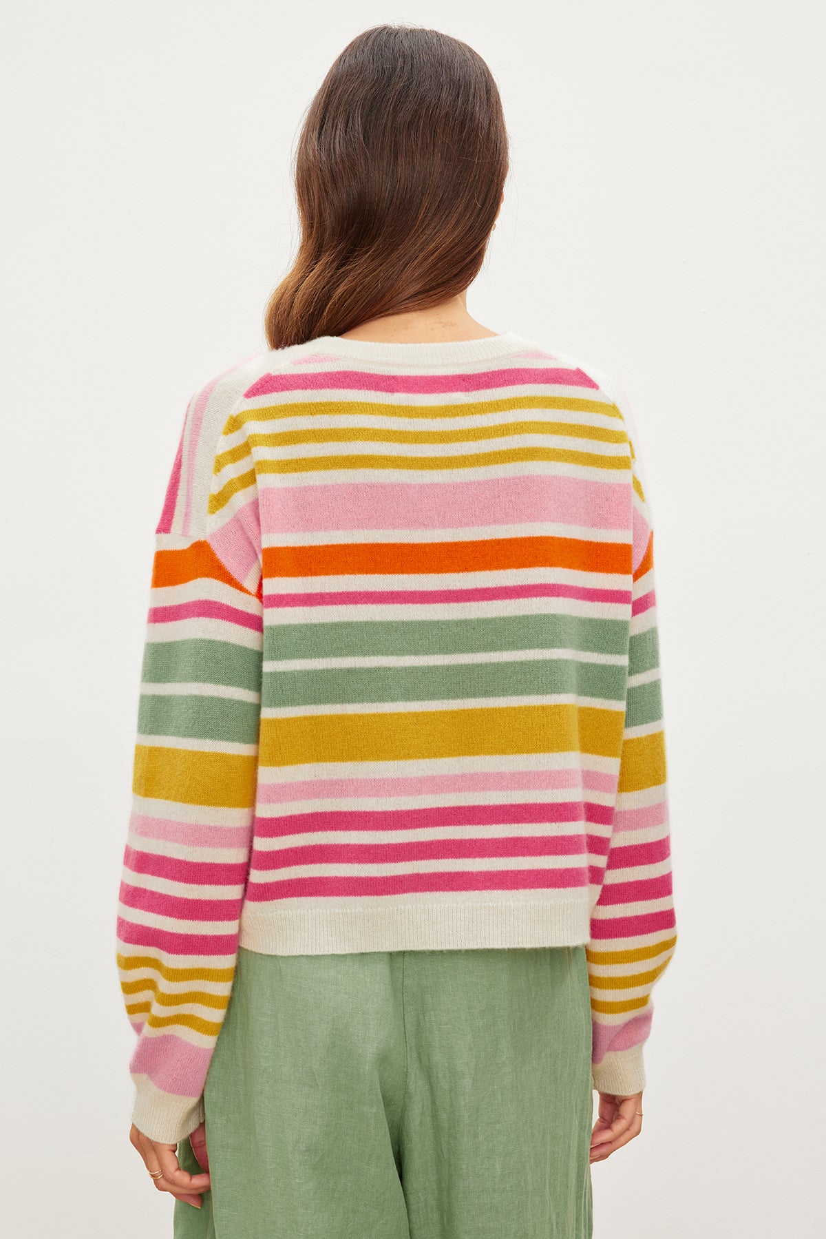   The back view of a woman wearing a Velvet by Graham & Spencer ANNY CASHMERE STRIPED CREW NECK SWEATER with multi-colored stripes. 