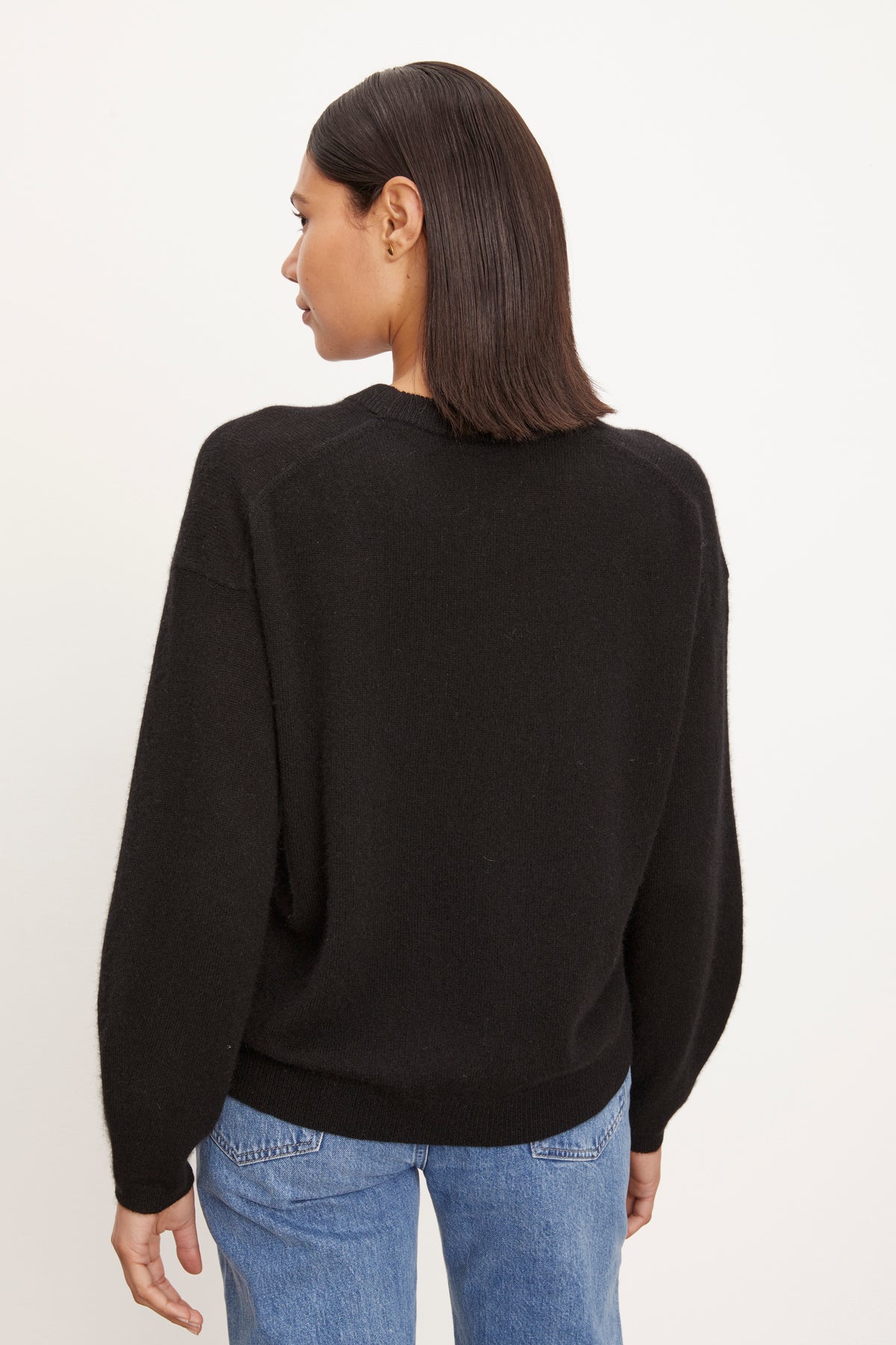   The back view of a woman wearing a Velvet by Graham & Spencer BRYNNE CASHMERE CREW NECK SWEATER and jeans. 