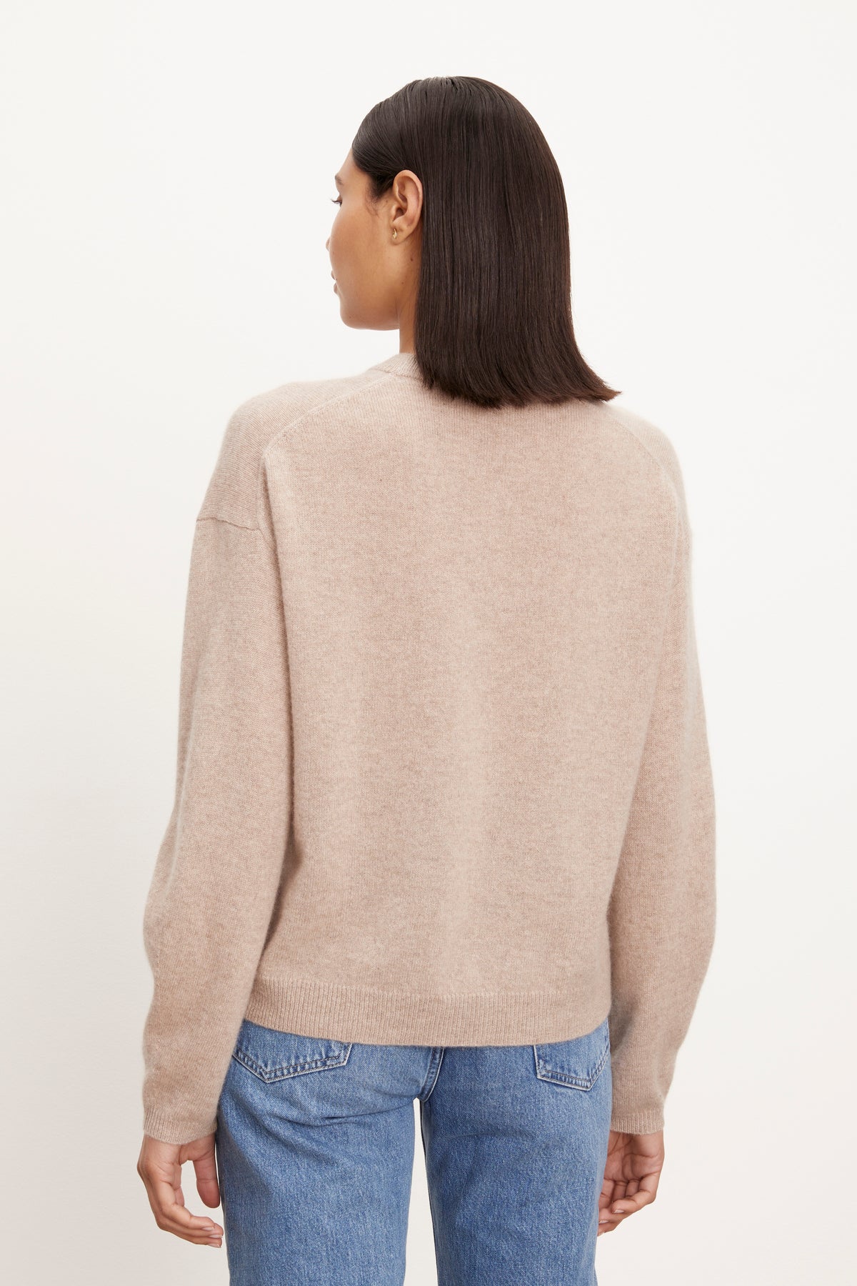   The back view of a woman wearing a Velvet by Graham & Spencer BRYNNE CASHMERE CREW NECK SWEATER and jeans. 