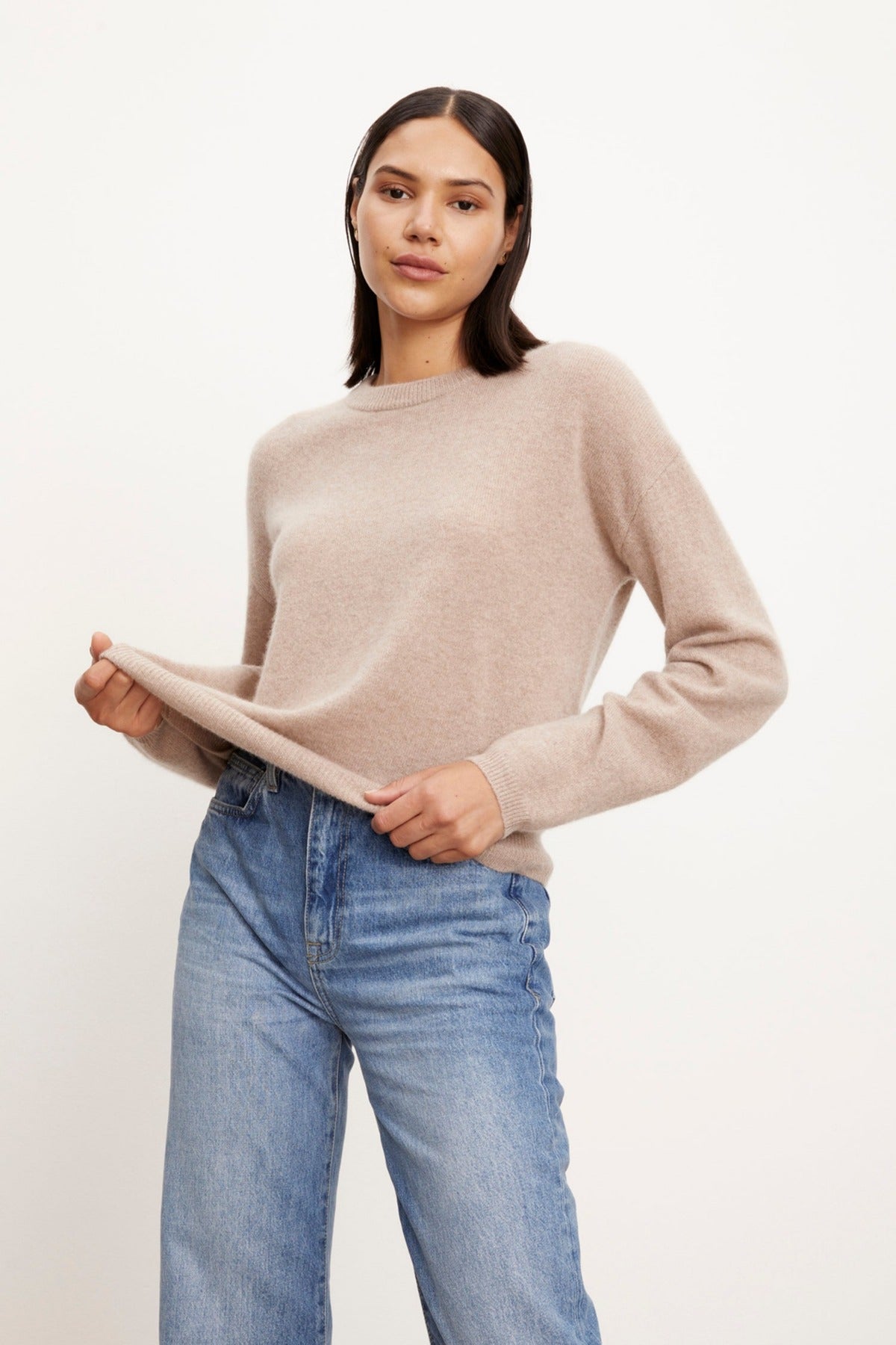 The model is wearing the Velvet by Graham & Spencer BRYNNE CASHMERE CREW NECK SWEATER with crewneck and ribbed trims, paired with blue jeans.-26883604480193