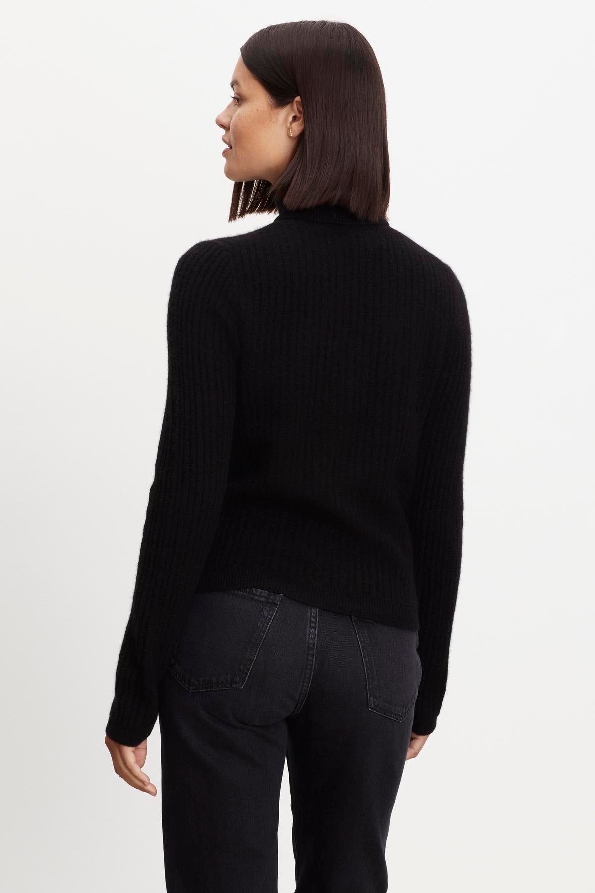   A woman in a Velvet by Graham & Spencer Lori Cashmere Turtleneck Sweater. 