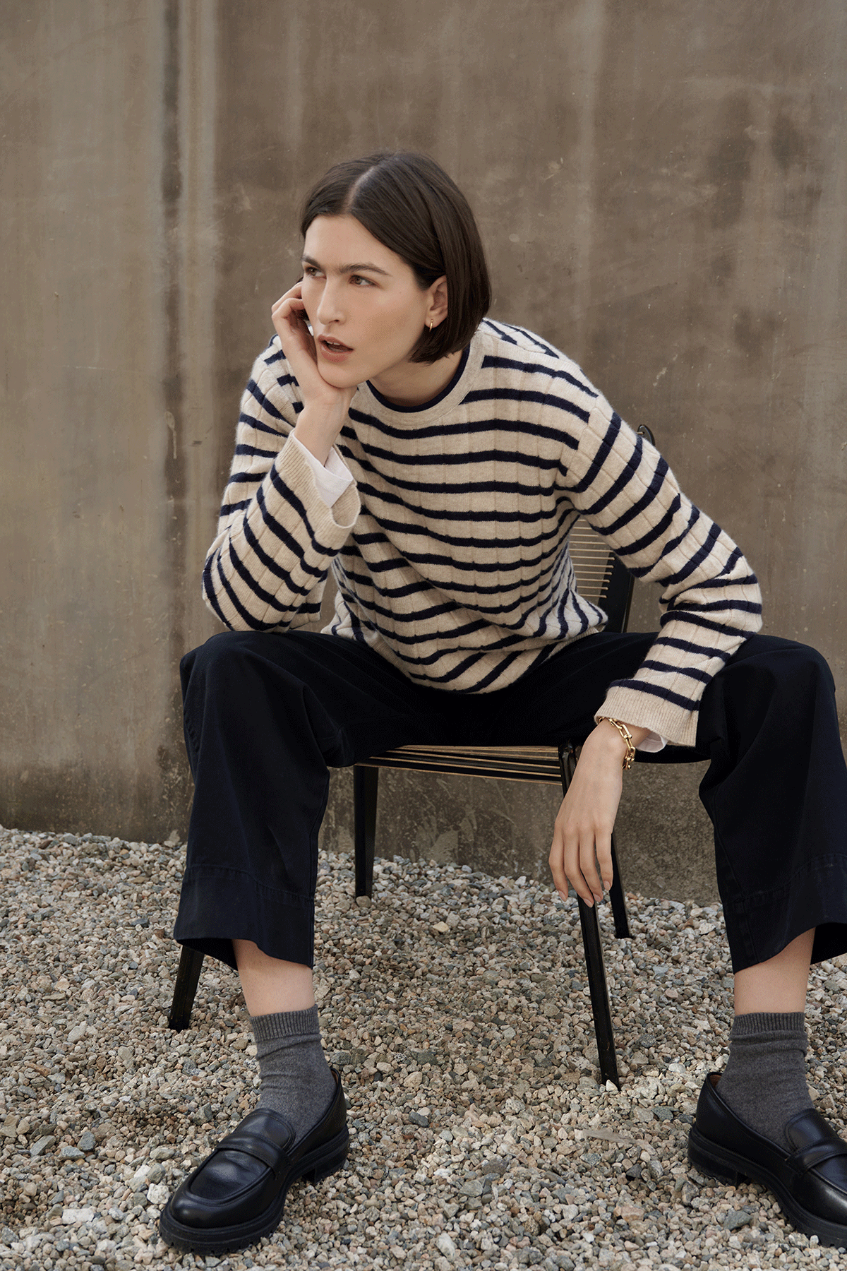   A woman in a Velvet by Jenny Graham striped NAPA SWEATER sitting on a chair. 
