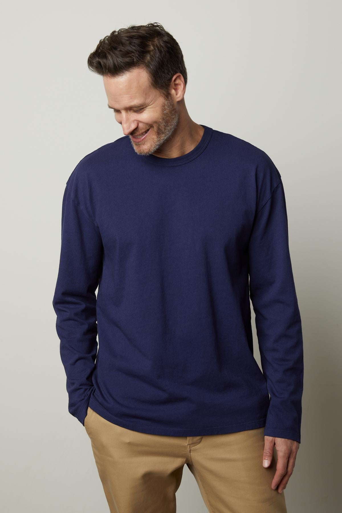 A man wearing a Velvet by Graham & Spencer EDWARD CREW NECK TEE in blue and khaki pants.-35472064807105