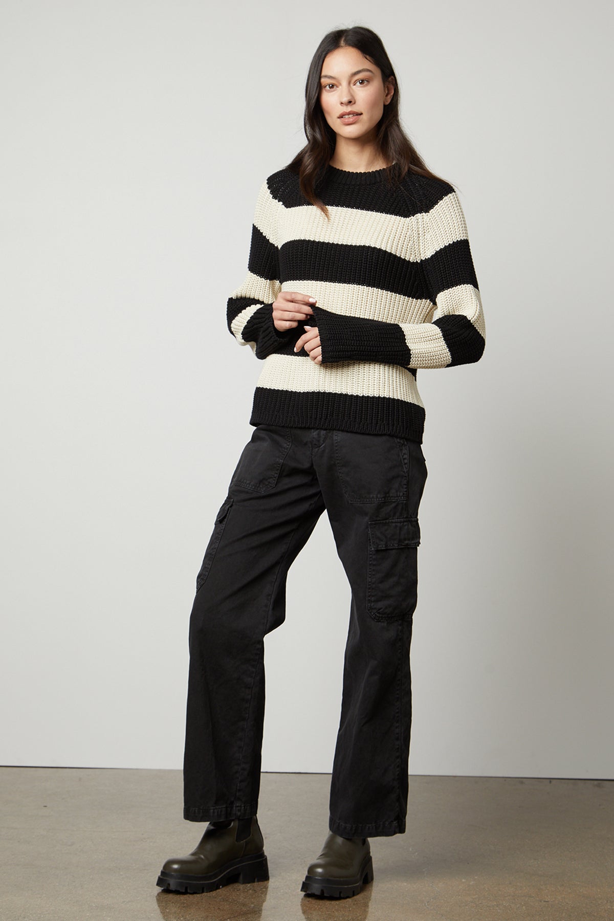 The model is wearing a Velvet by Graham & Spencer CIARA STRIPED CREW NECK SWEATER, providing warmth and comfort.-35507450544321