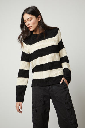 A woman wearing the Velvet by Graham & Spencer CIARA STRIPED CREW NECK SWEATER.