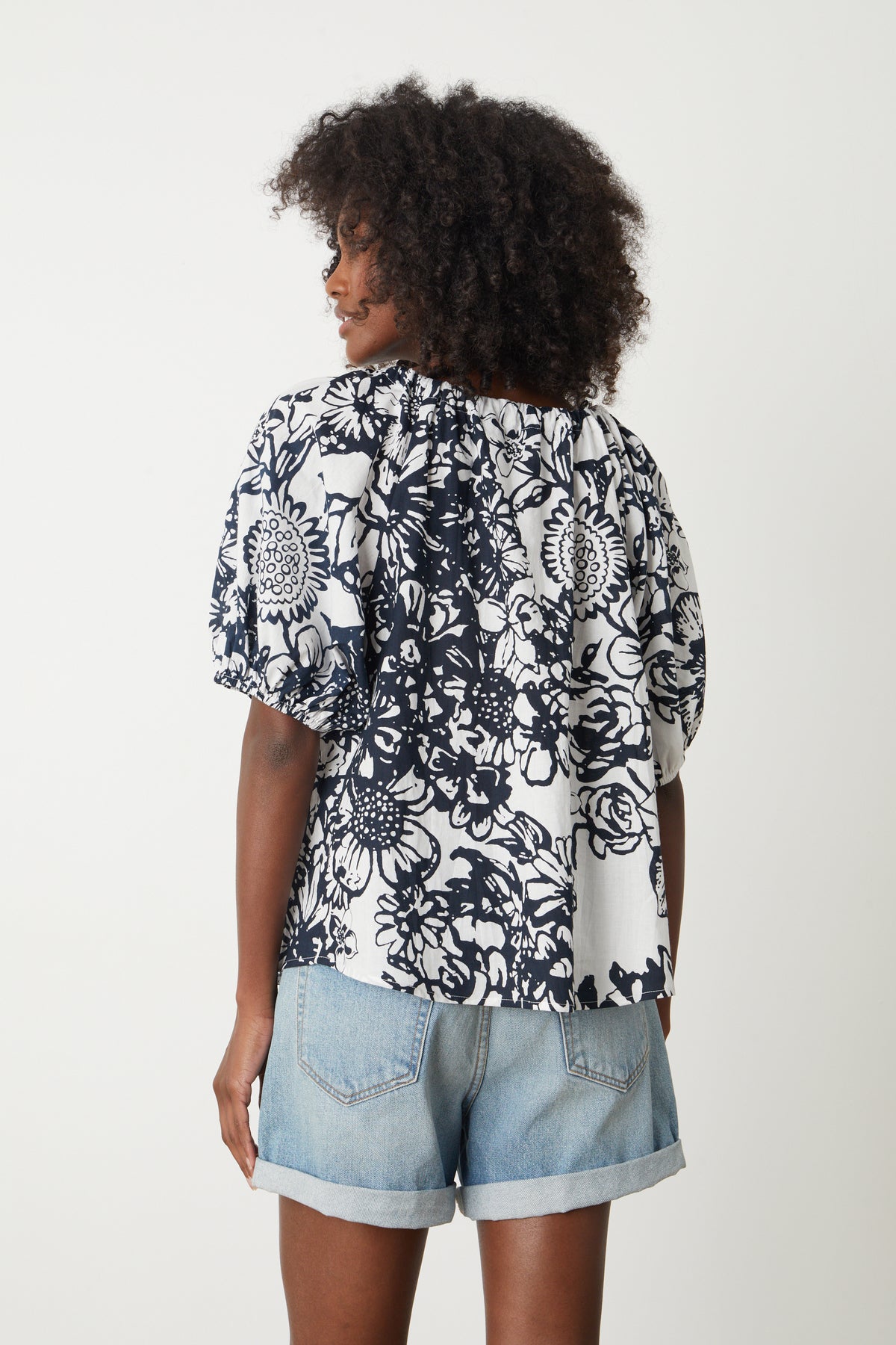   The back view of a woman wearing a Velvet by Graham & Spencer ANGELA PRINTED BOHO TOP. 