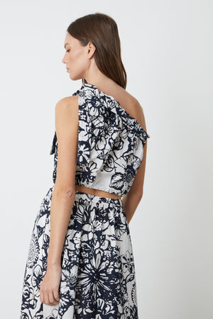 The back view of a woman in a Velvet by Graham & Spencer CAMILLA PRINTED ONE SHOULDER TOP.