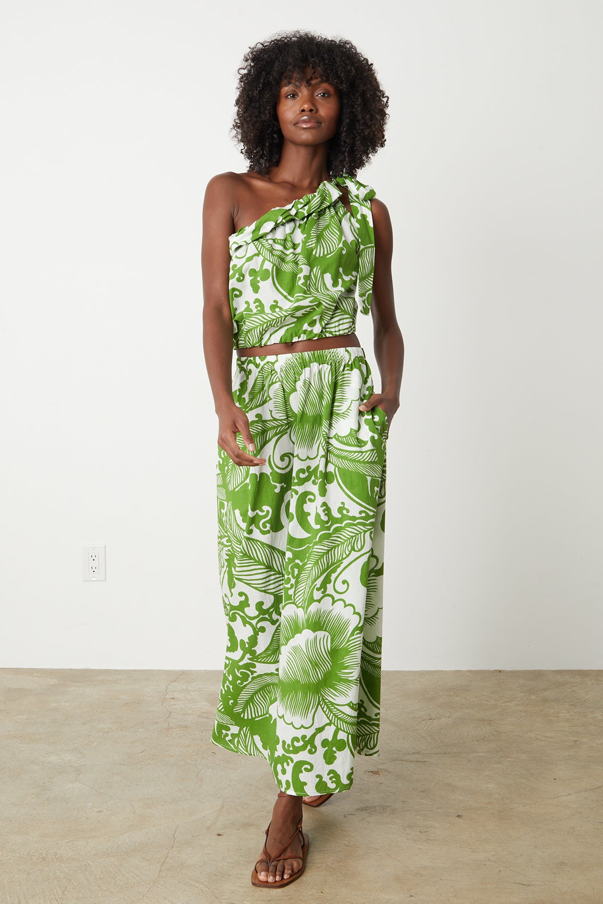   a woman wearing a Velvet by Graham & Spencer green and white floral maxi dress 