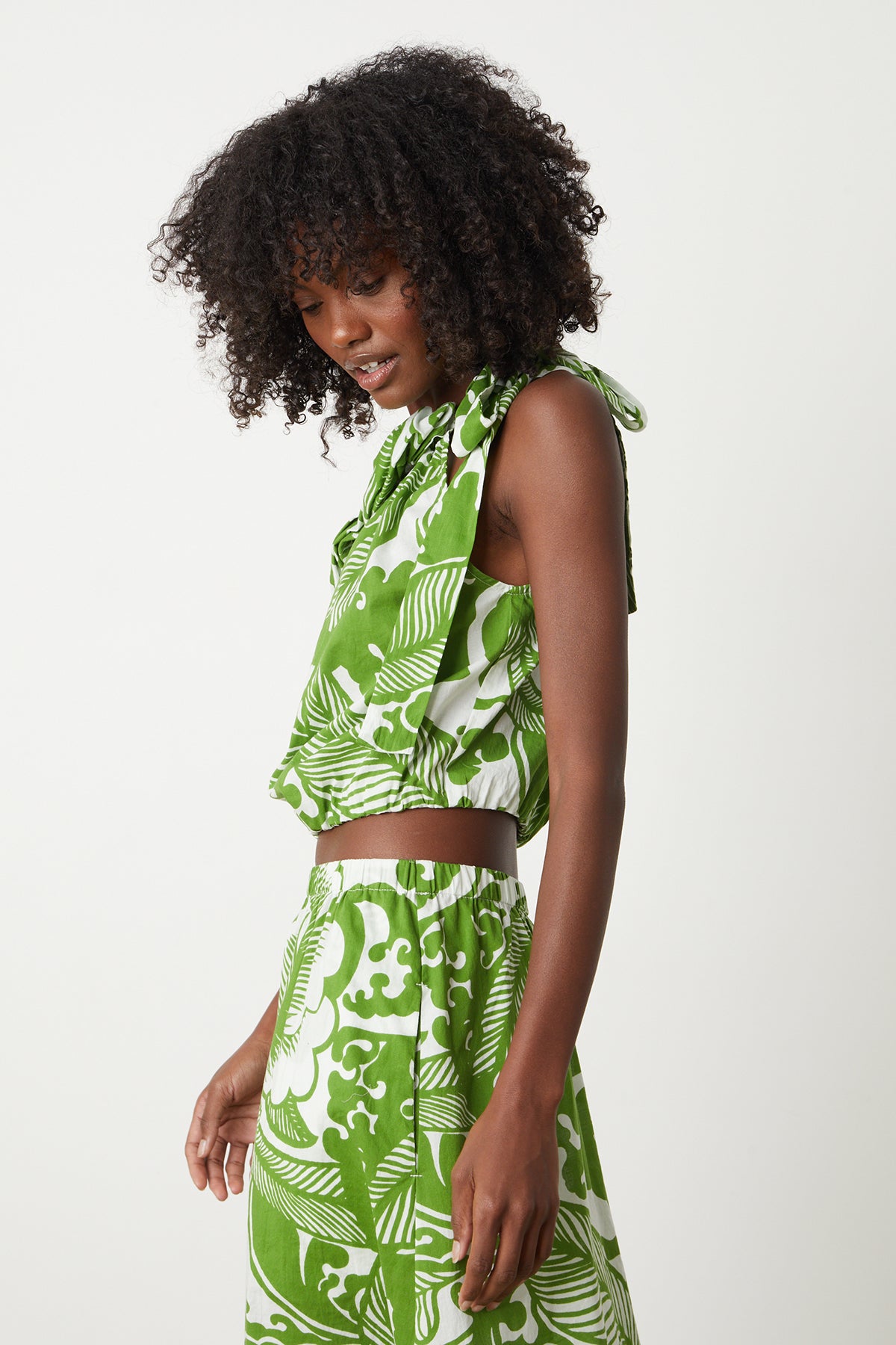 A woman wearing a Velvet by Graham & Spencer CAMILLA PRINTED ONE SHOULDER TOP and shorts.-26342690816193