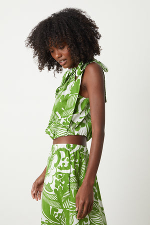 A woman wearing a Velvet by Graham & Spencer CAMILLA PRINTED ONE SHOULDER TOP and shorts.