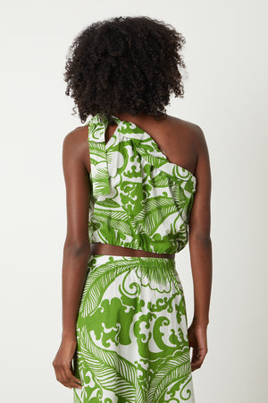 the back view of a woman in a Velvet by Graham & Spencer CAMILLA PRINTED ONE SHOULDER TOP dress.