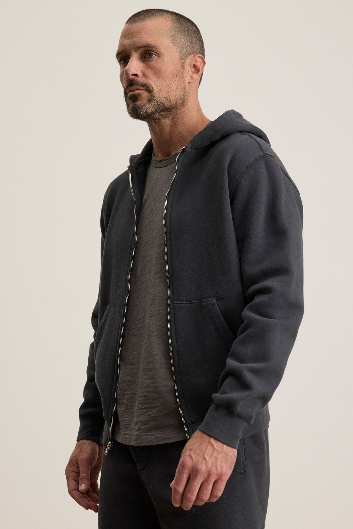 A man wears the Velvet by Graham & Spencer BRADFORD HOODIE over a gray t-shirt, standing against a plain light background.-40606021320897