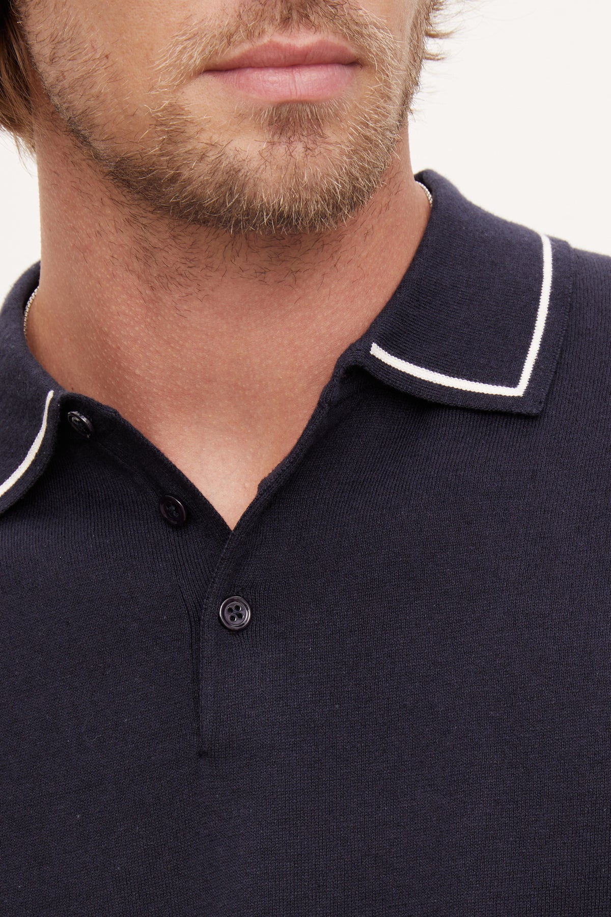   Close-up of a man's lower face and neck showing a Velvet by Graham & Spencer Shepard Polo with white trim on the collar. 