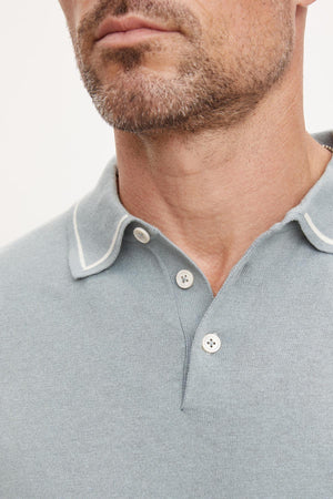 Close-up of a man wearing a gray Velvet by Graham & Spencer Shepard Polo with a three-button placket and collar detailing, focusing on the neckline and lower face.