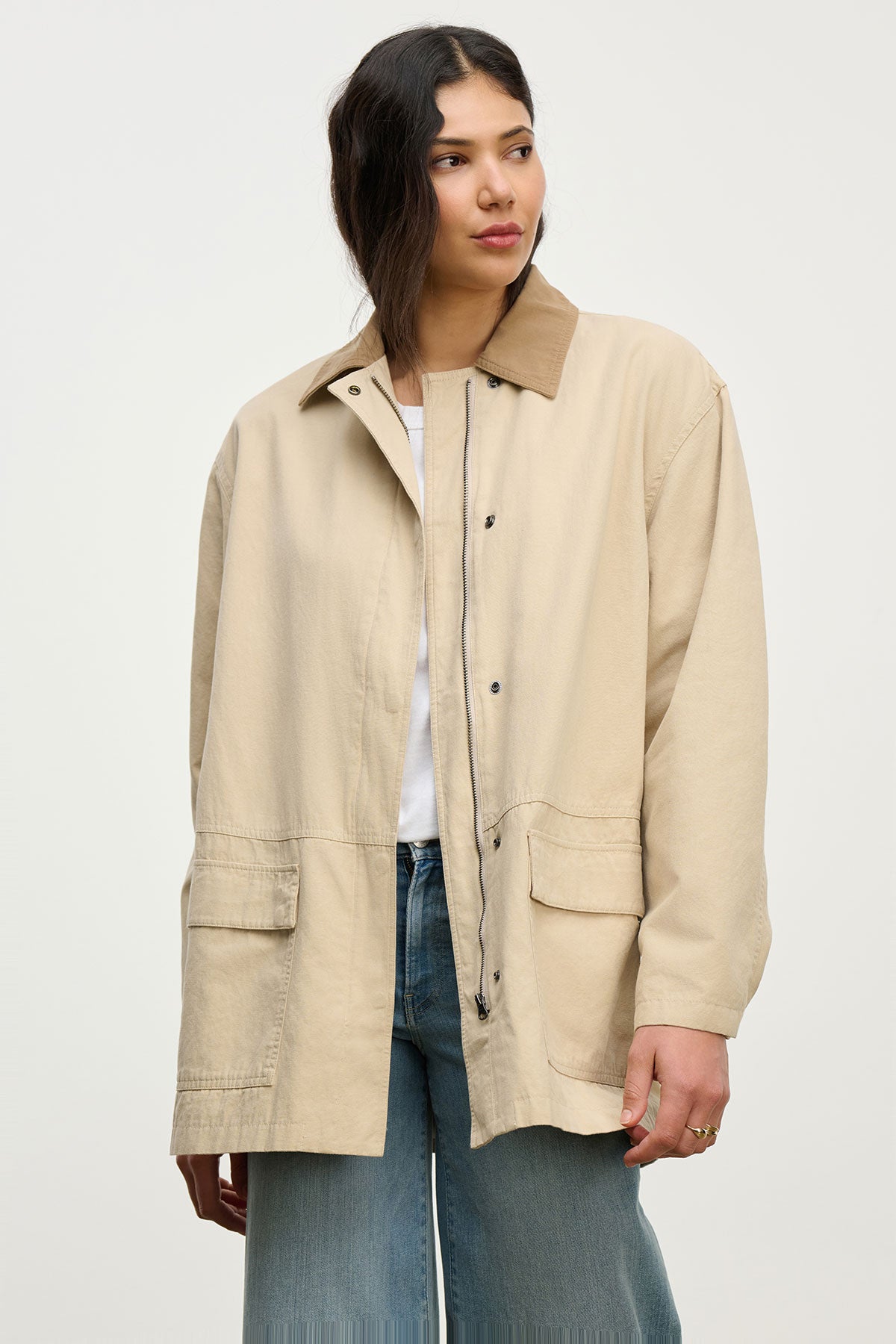 A person wearing the ROSA JACKET by Velvet by Graham & Spencer over a white shirt and blue jeans stands against a plain, light background—perfect for effortless everyday style.-39654933725377