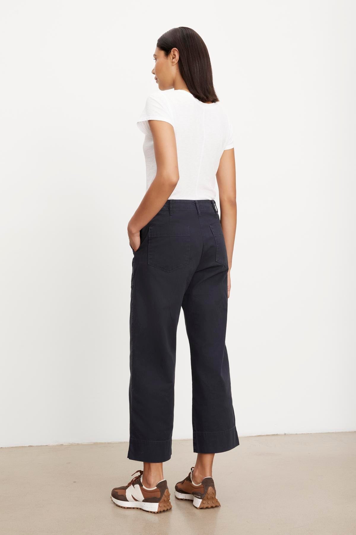   Woman standing in a white top and dark Velvet by Graham & Spencer MYA COTTON CANVAS PANT, viewed from the side. 
