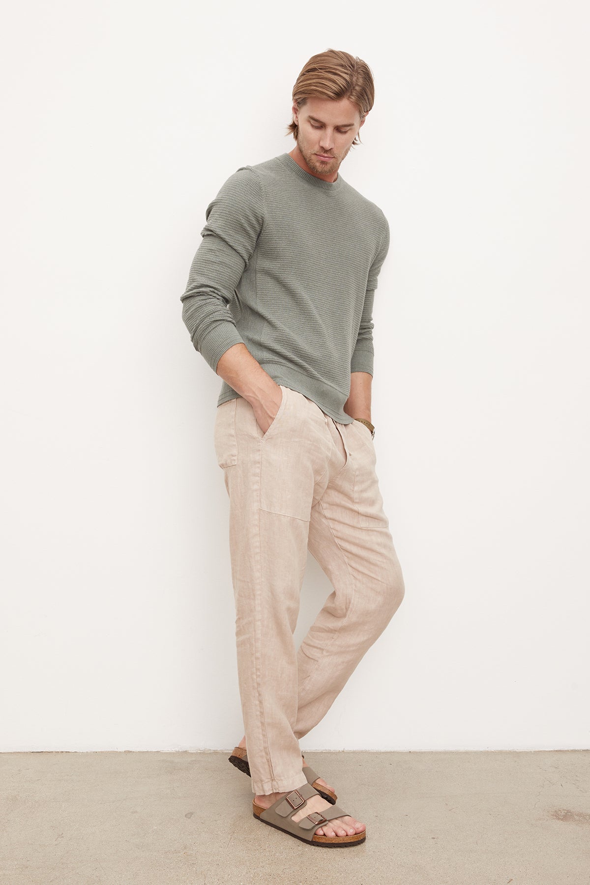A man wearing tan linen pants and a green long-sleeve Velvet by Graham & Spencer ACE THERMAL CREW.-36212340654273