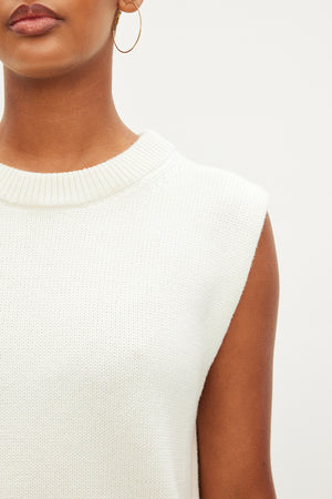 A woman in a luxurious white Velvet by Graham & Spencer ASTER CREW NECK SWEATER, crafted from a blend of cotton and cashmere for ultimate comfort.