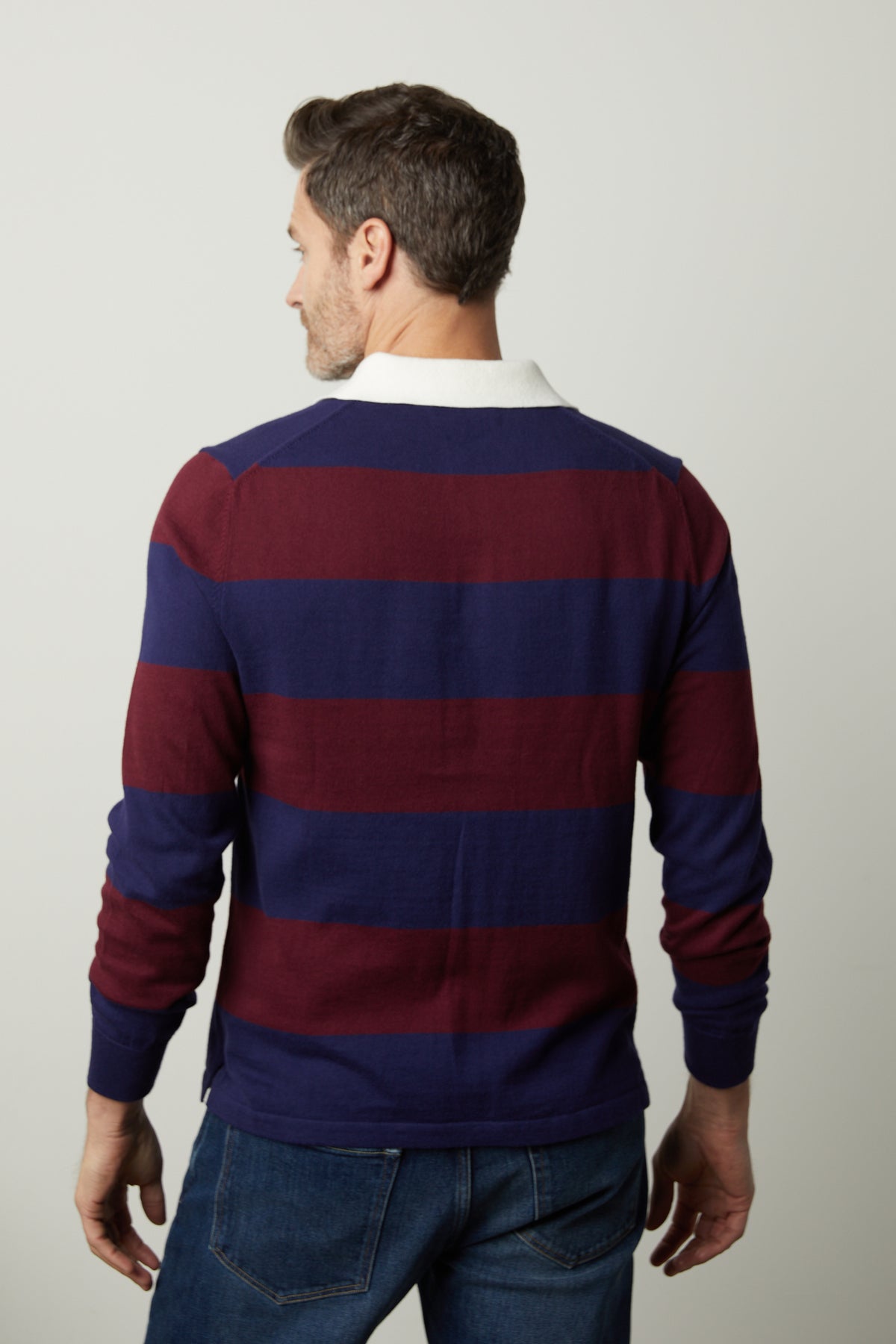 The back view of a man wearing a Velvet by Graham & Spencer HASTINGS STRIPED POLO SWEATER.-26768020275393